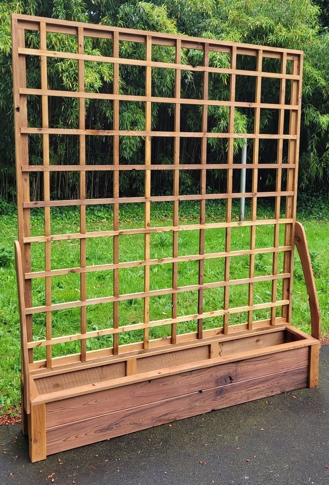 Elevated cedar planter box with a tall lattice trellis and curved arm supports
